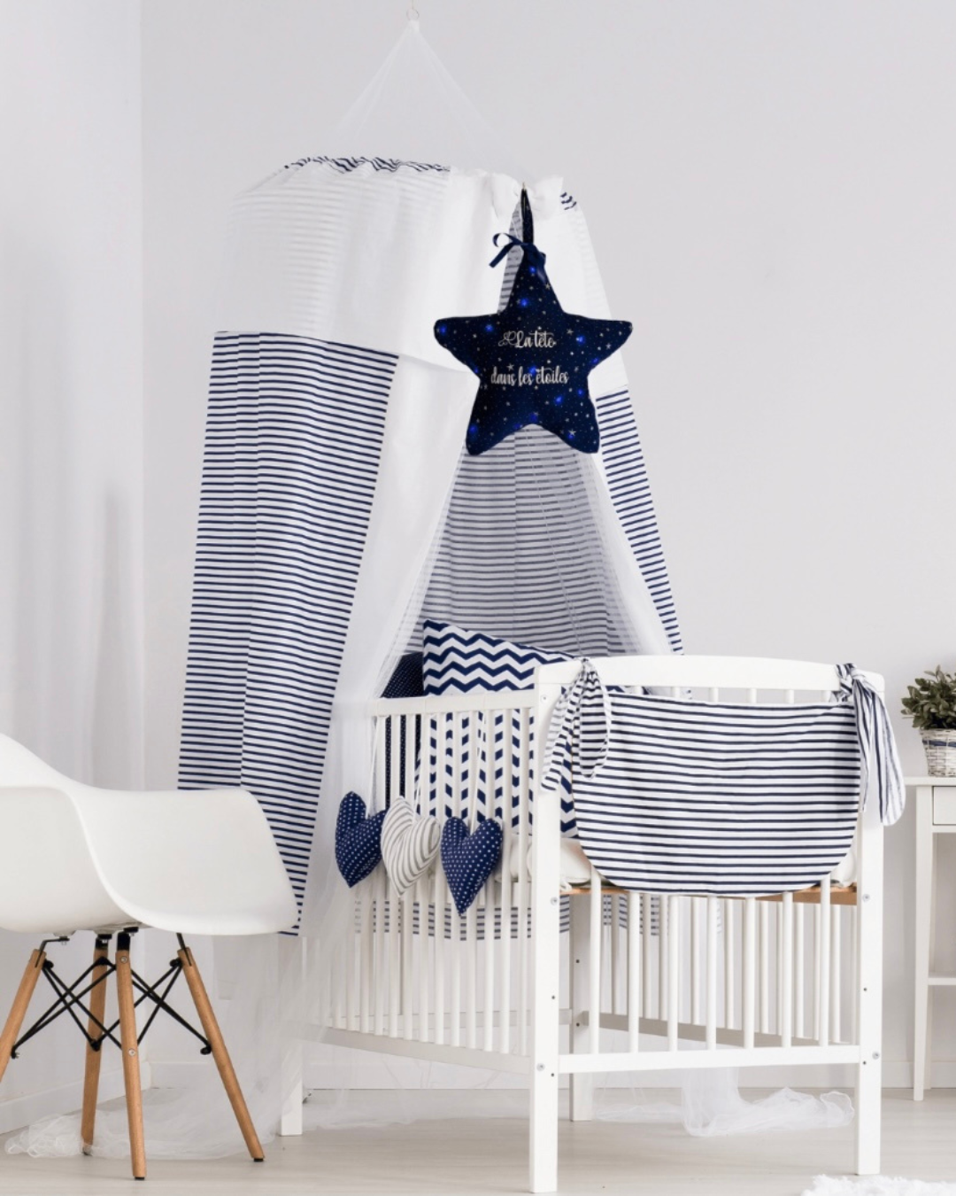 eilleuse étoile personnalisée suspendue au-dessus d'un lit bébé, en tissu bleu nuit avec message "La tête dans les étoiles"