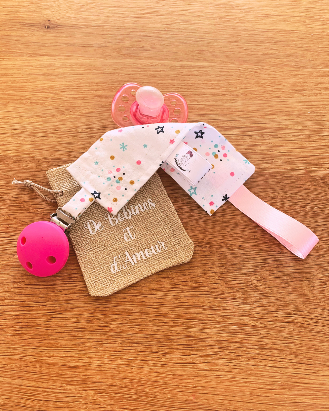 attache-tetine-bebe-tissu-fantaisie-etoiles Attache tétine personnalisée en tissu a motifs étoiles, avec clip sécurise rose et pochette