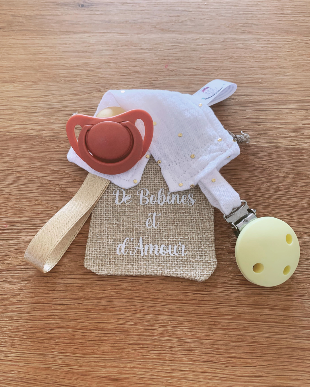 attache-tetine-blanche-doree Attache tétine blanche en double gaze avec pois dores, clip jaune pastel