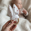 anneau de dentition personnalisé bébé en bois naturel avec oreilles lapin tenu à la main