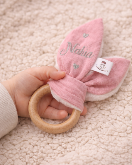 Anneau de dentition personnalisé en bois naturel tenu par un bébé